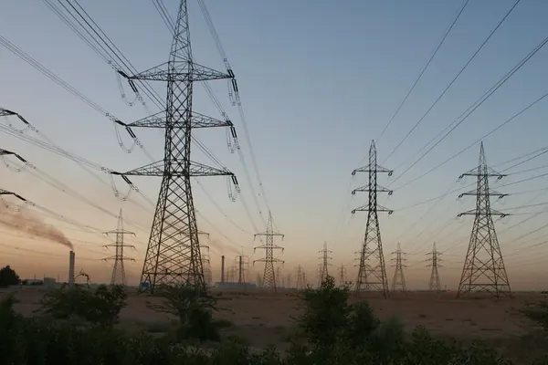 High-voltage pylons and power lines at sunset