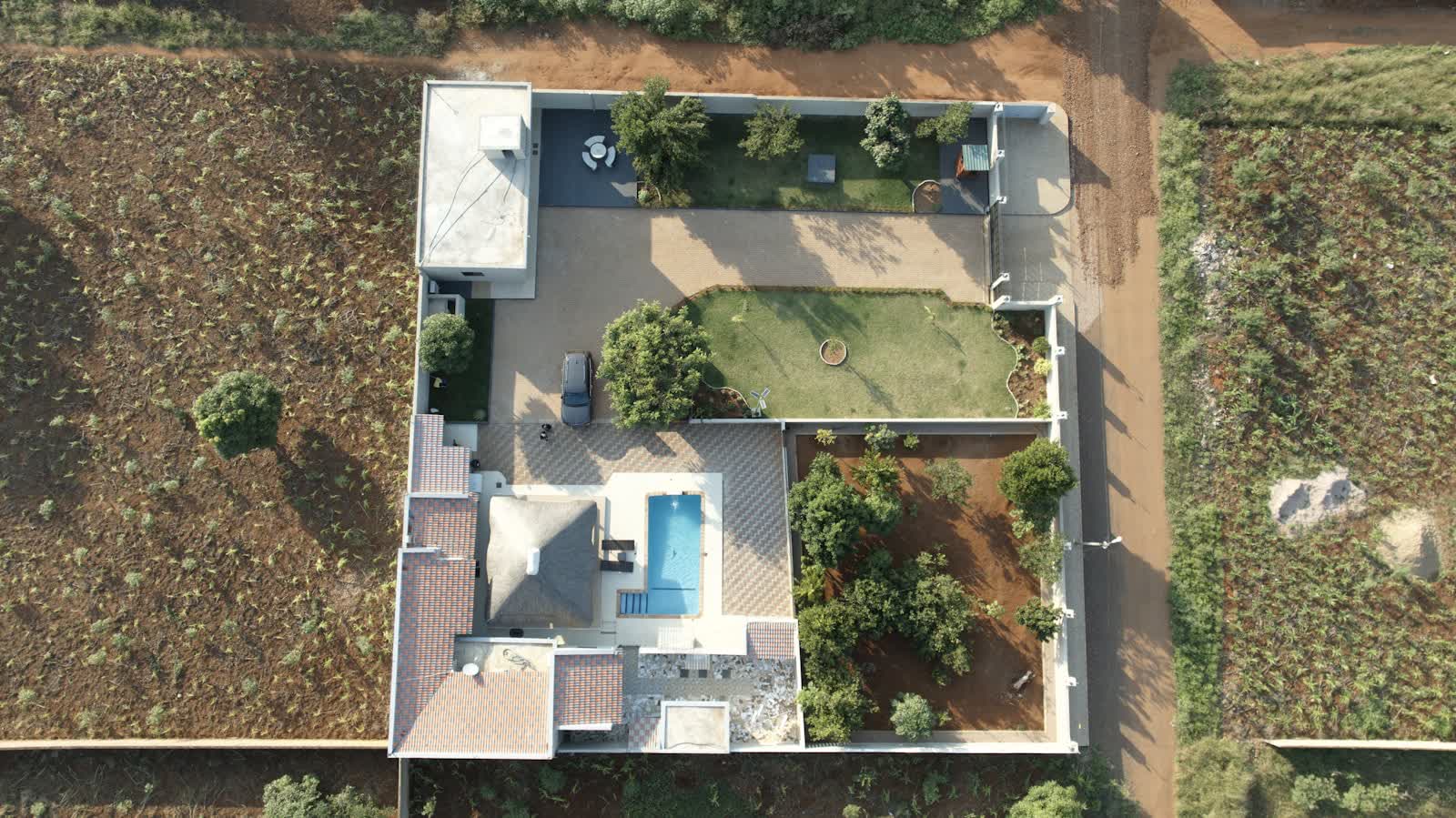 Aerial view of a property with villa, swimming pool and garden